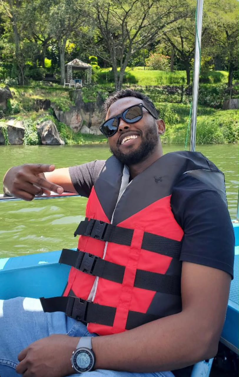 Abdishakur Yusuf smiling on a boat in a red life jacket