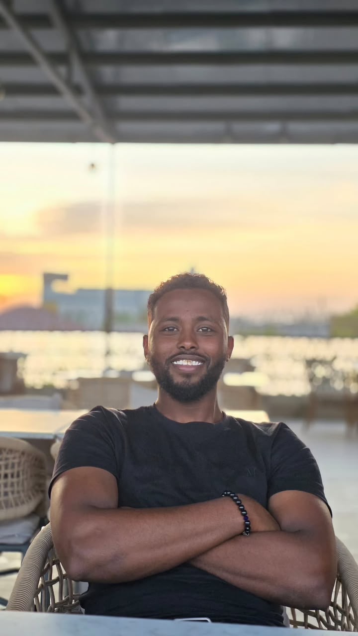 Abdishakur Yusuf seated at a cafe at sunset
